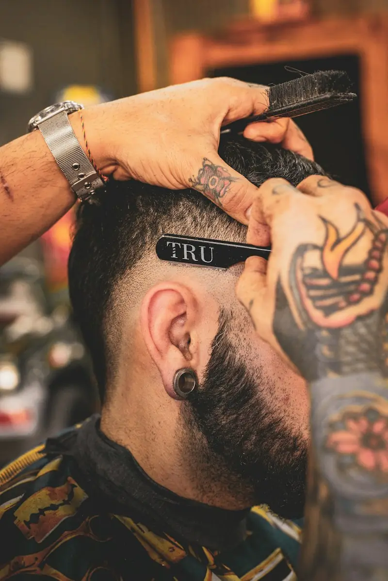 Herrenschnitt mit Fade und rasierter Linie, Bart geformt