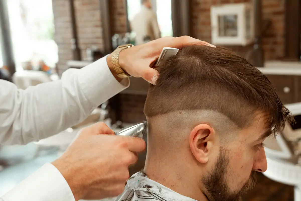 Barber schneidet einem Mann einen Fade mit der Maschine