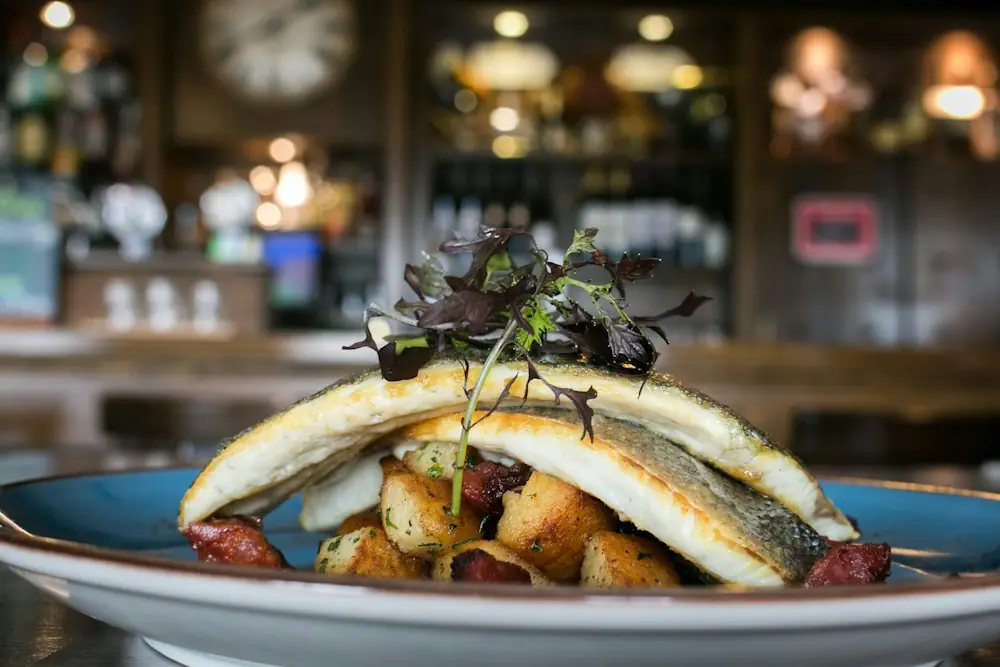 Gebratene Fischfilets mit Kartoffeln auf einem blauen Teller